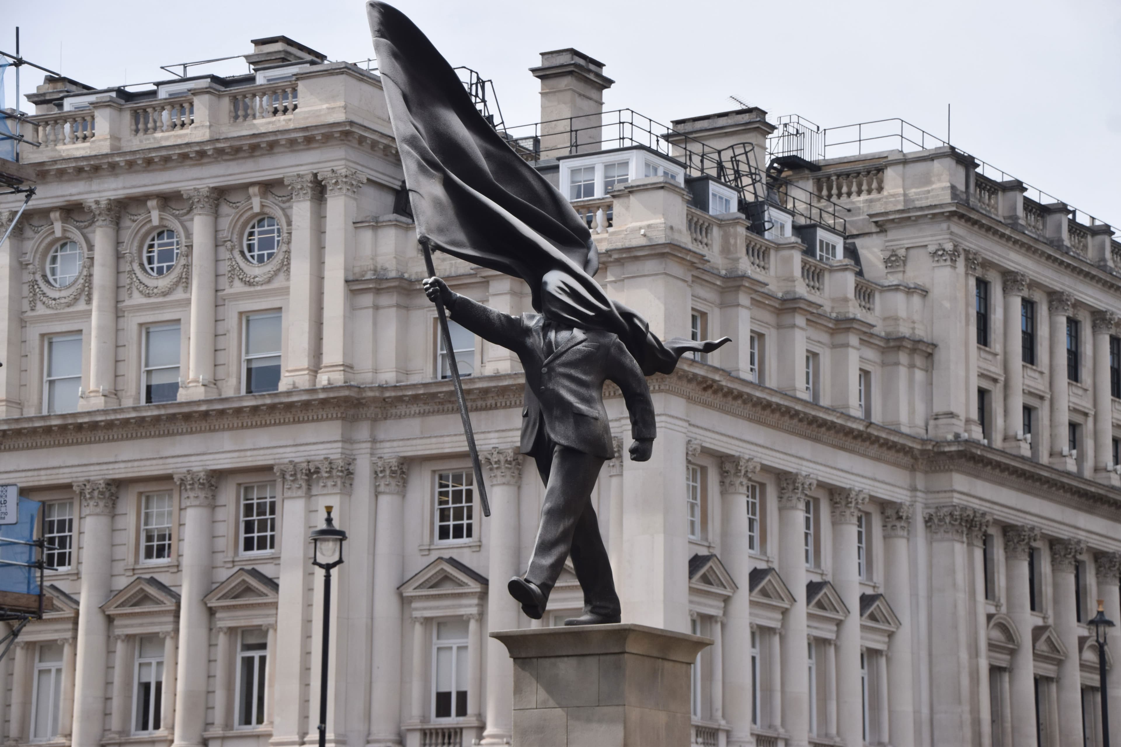 New Statue Attributed to Banksy Depicts Suited Man, Blinded by Flag, Walking Off a Ledge in Central London
